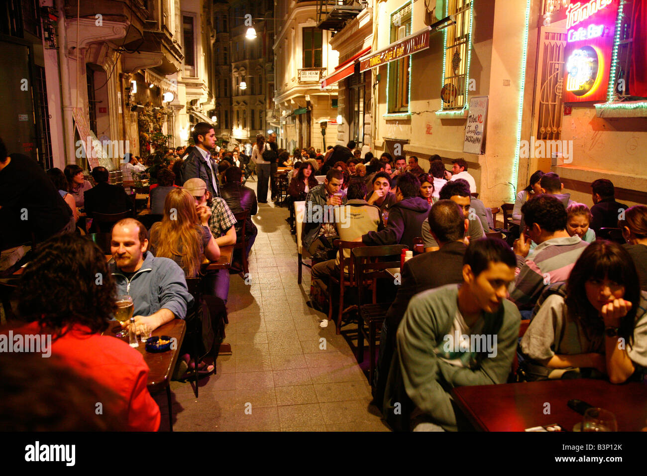 May 2008 - Young people sitting in the street by some bars and cafes in the Beyoglu Istanbul Turkey Stock Photo
