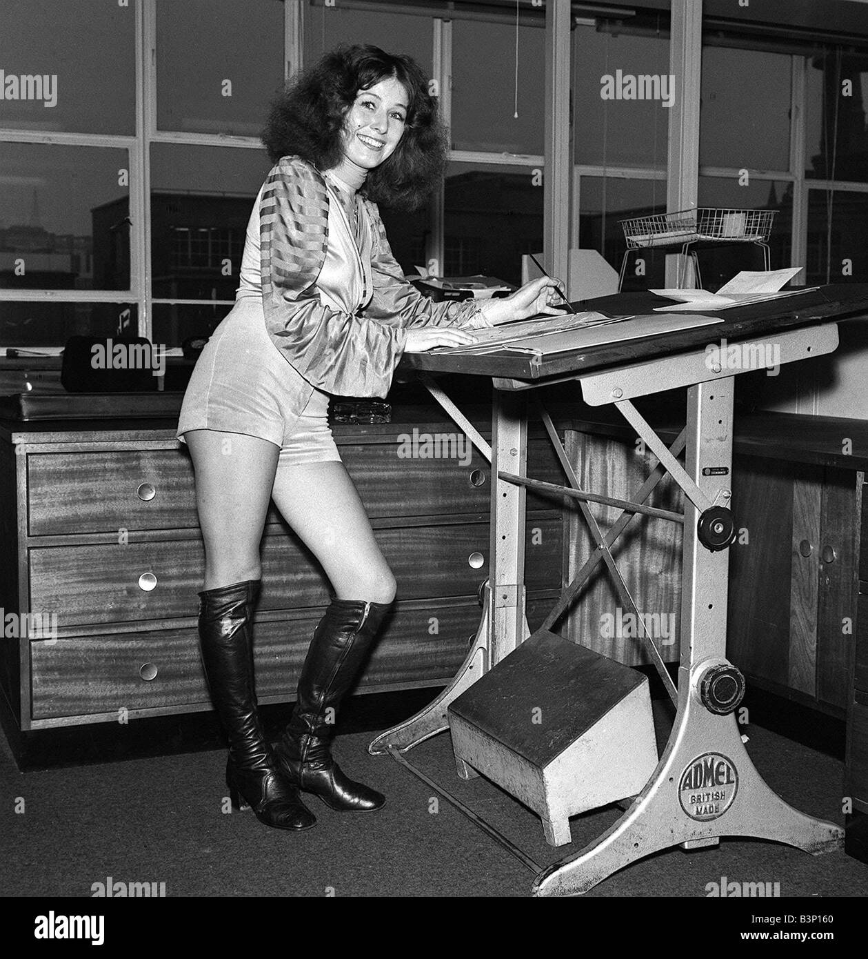 Fashion Shorts Seventies 1970 s Designer and artist working at station wearing hotpants and knee high boots Stock Photo