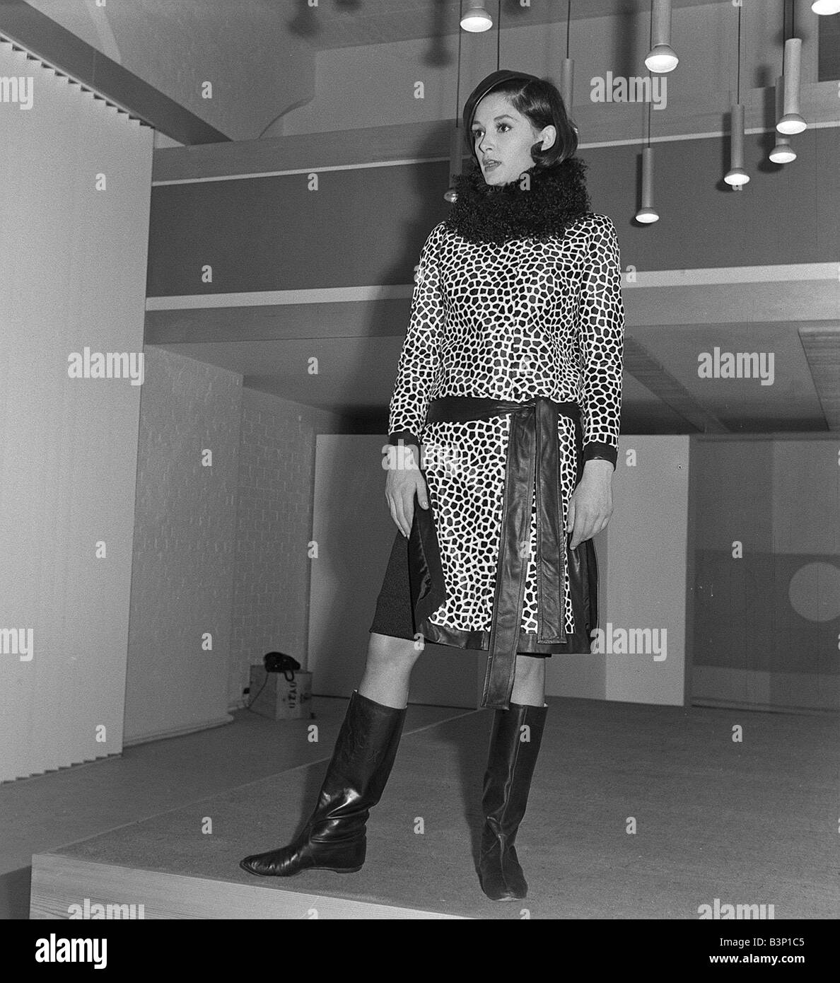 Mary Quant fashion clothing Wearing a leopard print dress with fur collar and knee high boots looking bored annoyed Stock Photo