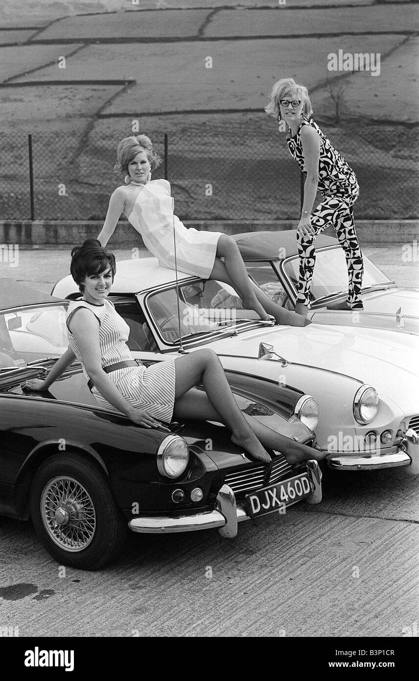Googl Eye Boutique Owners April 1966 Gail Meredith L Anne Earnshaw C and Sue Hellowell R Glasses owner of a boutique called Googl Eye based in the village of Luddenfoot near Halifax in Yorkshire The girls who are all mothers have bought matching Triumph Spitfire sports cars Three women posing on cars Stock Photo