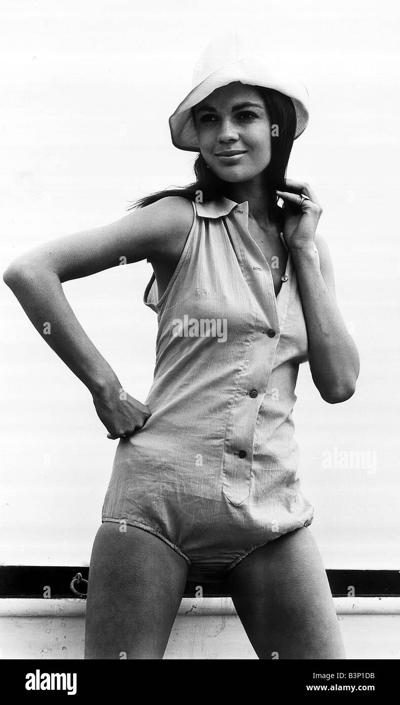 Virginia North modelling beach fashion a one piece outfit with button detail and matching hat standing with one hand on her hip Stock Photo