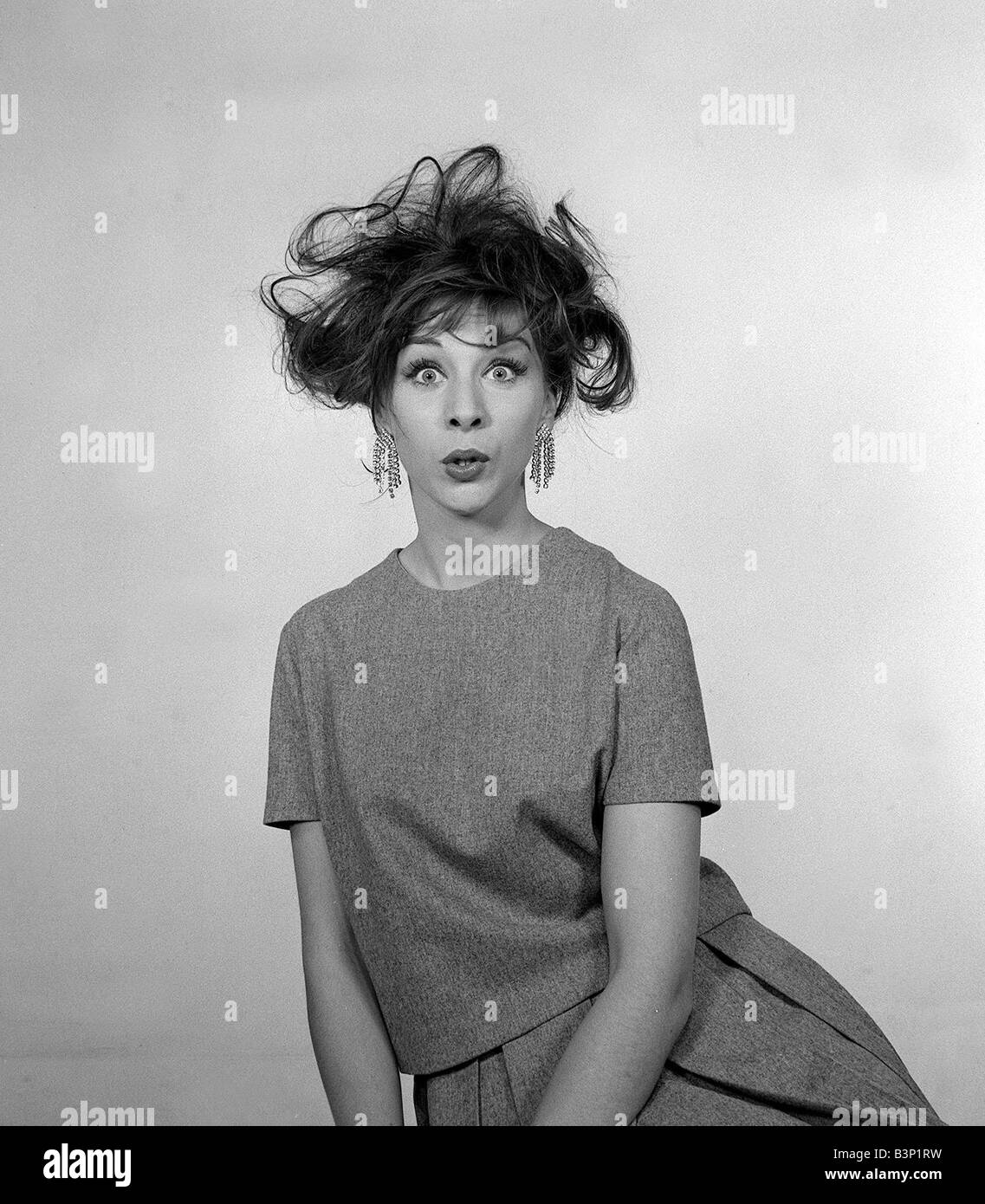 1960s Fashion Hair Styles December 1960 Woman pulling a bemused shocked  facial expression with a messed up tousled hair style Stock Photo - Alamy