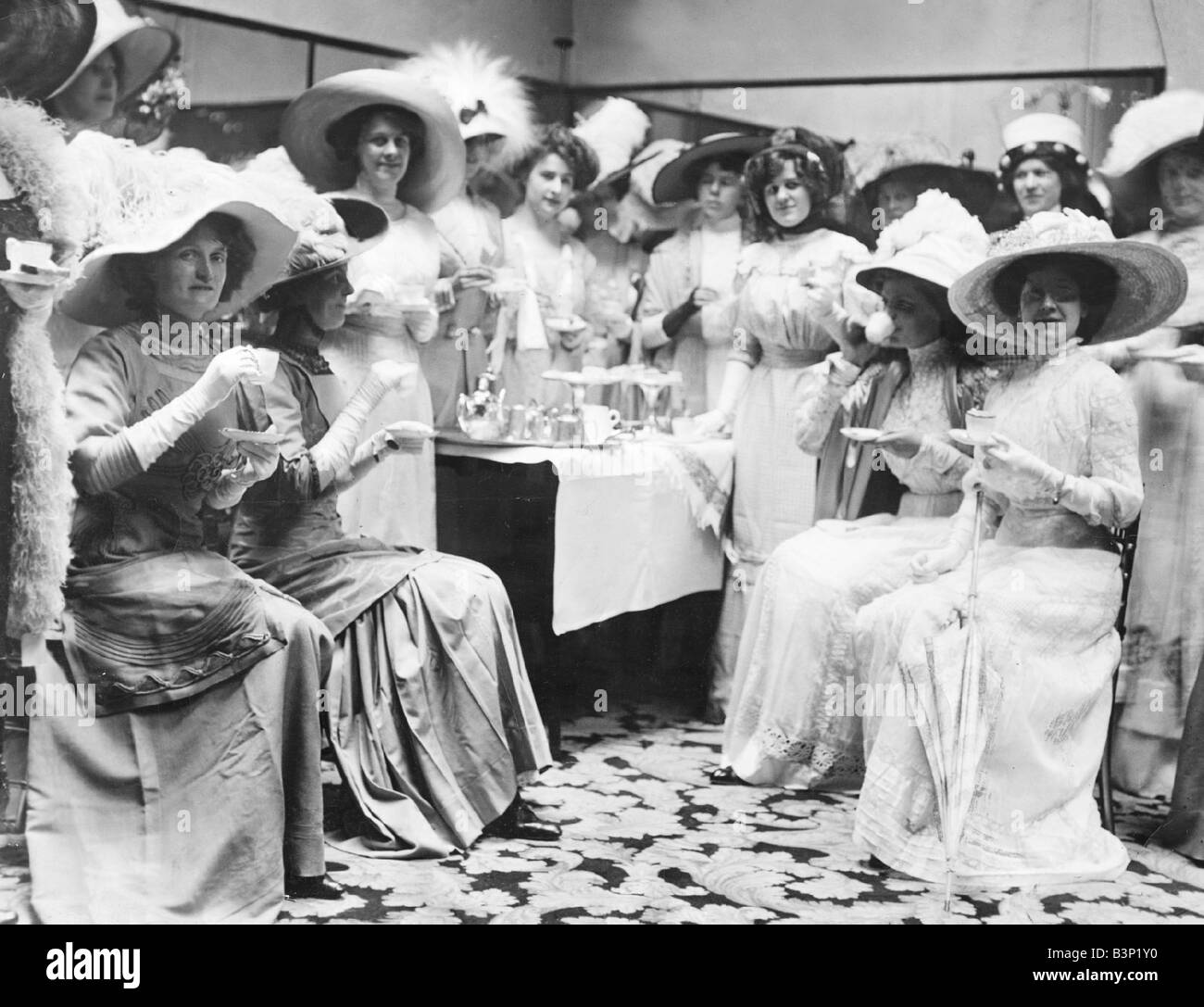 Clothing Fashion Edwardian fashions 1920s Mannequins having a cup of tea at Whitley s Wearing white lace dresses and wide brimmed hats trimmed with feathers August 1910 Stock Photo