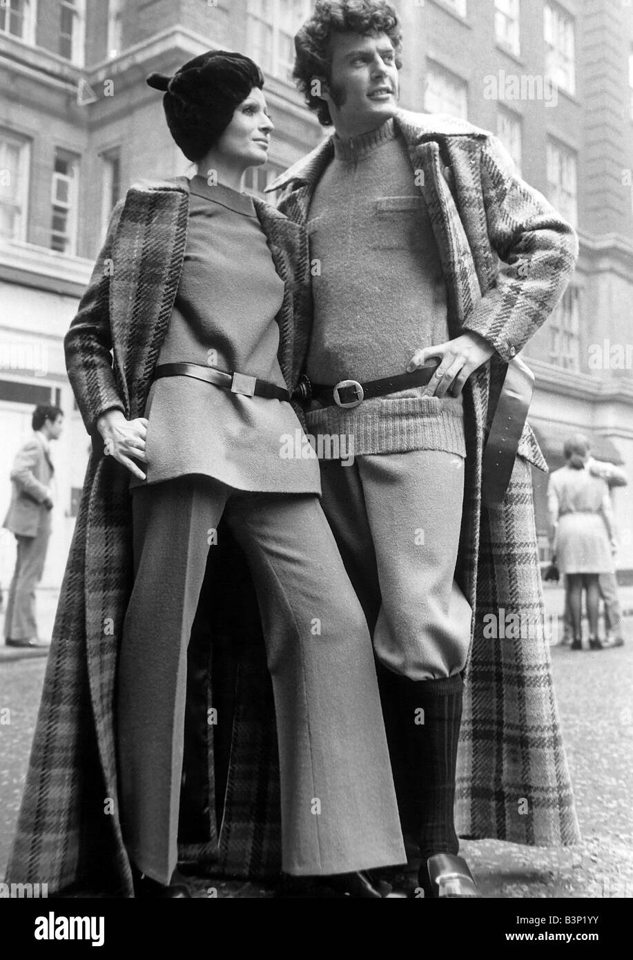 Clothing Fashion 1970 s Richard Asman in a full length tweed coat with breeches and sweater in camel colour wool shoes belt in Porvair and Marion Lane in matching outfit during a fashion show Mayfair Hotel October 1969 Stock Photo