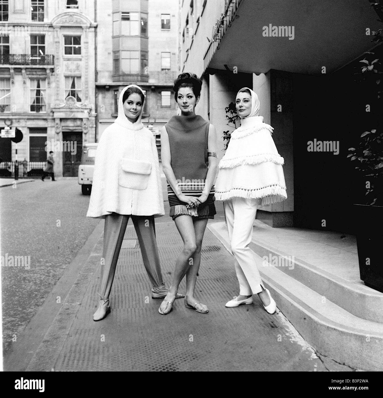 The cape became the item every girl wanted in 1962 Models posed in the street wearing the capes with the hoods over their heads Stock Photo