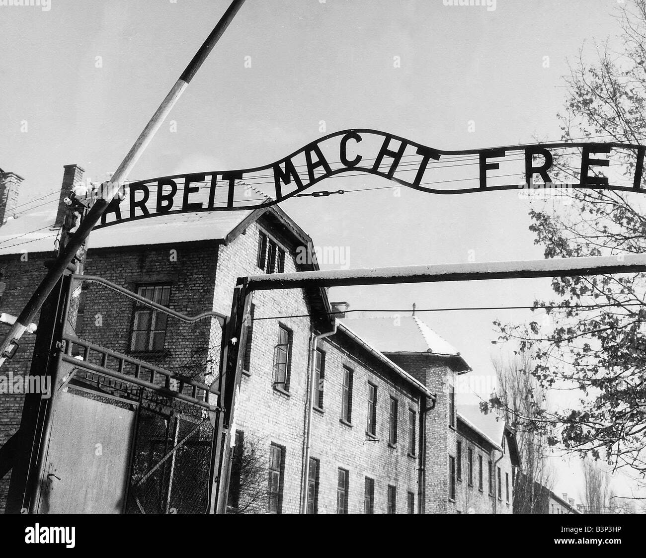 Entrance to Auschwitz concentration camp March 1964 in Poland where sign under the gate reads Work Makes Free Arbeit macht Frei Stock Photo