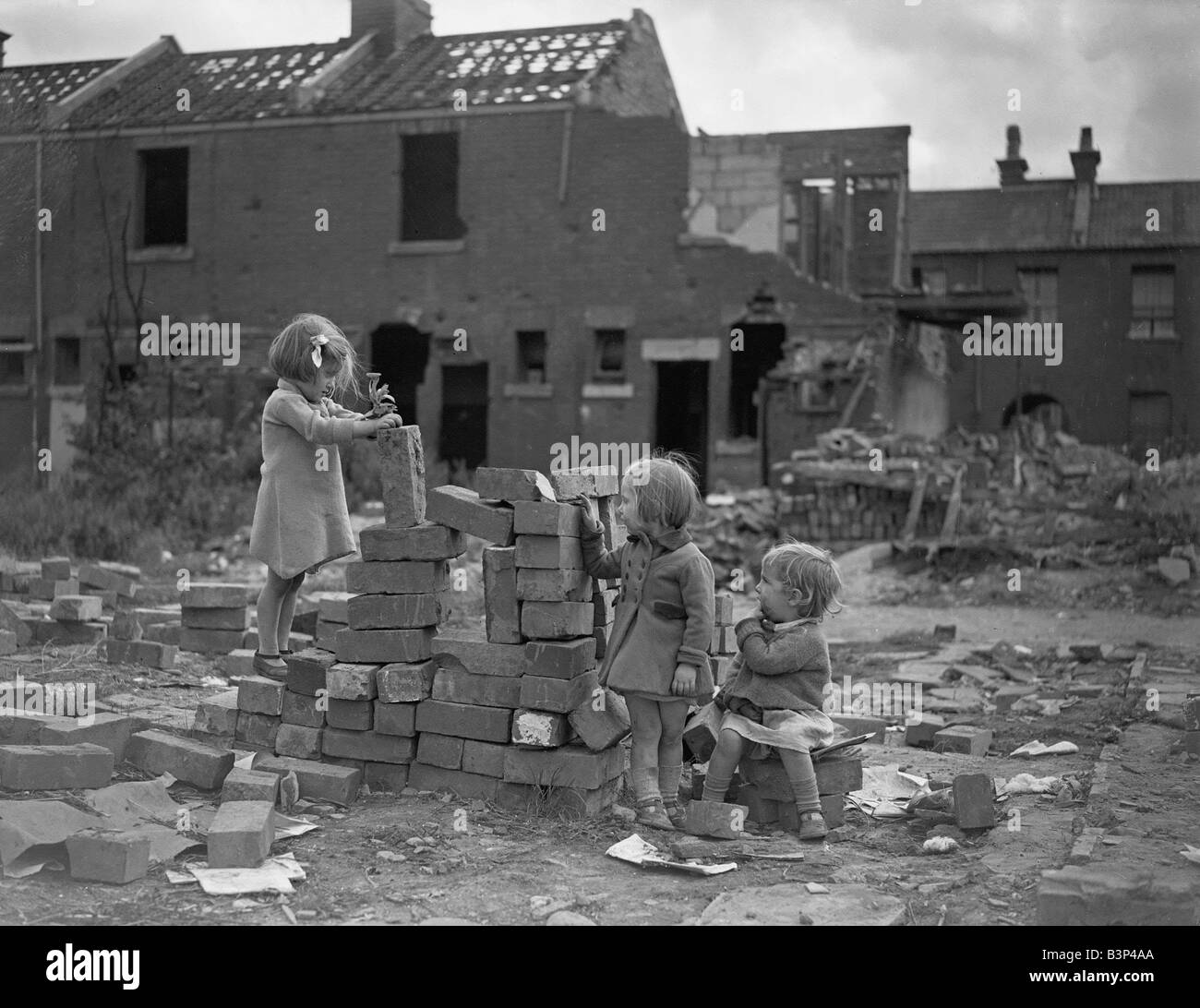 WW2 Children Playing Games Children playing games on a bomb site in London Three little girls play with bricks on the site of a Stock Photo