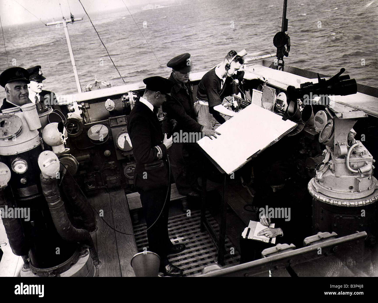 World War II Invasion of France Army artillery officer working with a Royal Navy gunner officer plot the next barrage on enemy postions in Normandy The guns of the Royal Navy s crusiers and battleships help subdue enemy fire during the first few weeks of Operation Overlord Sailors consulting a map one officer holding a telephone June 1944 Stock Photo