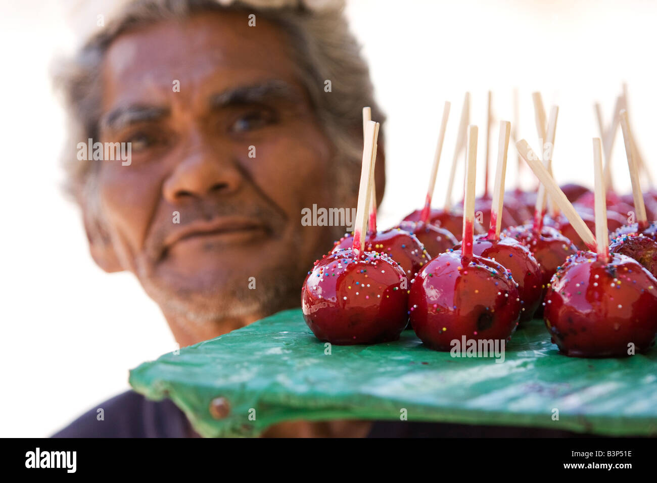 A man in Nicaragua selling candy covered apples ot toffee apples He has
