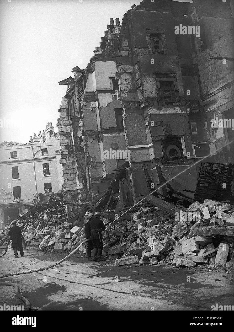WW2 Bath Bomb Damage Firemen pump water on the the damaged building Stock Photo
