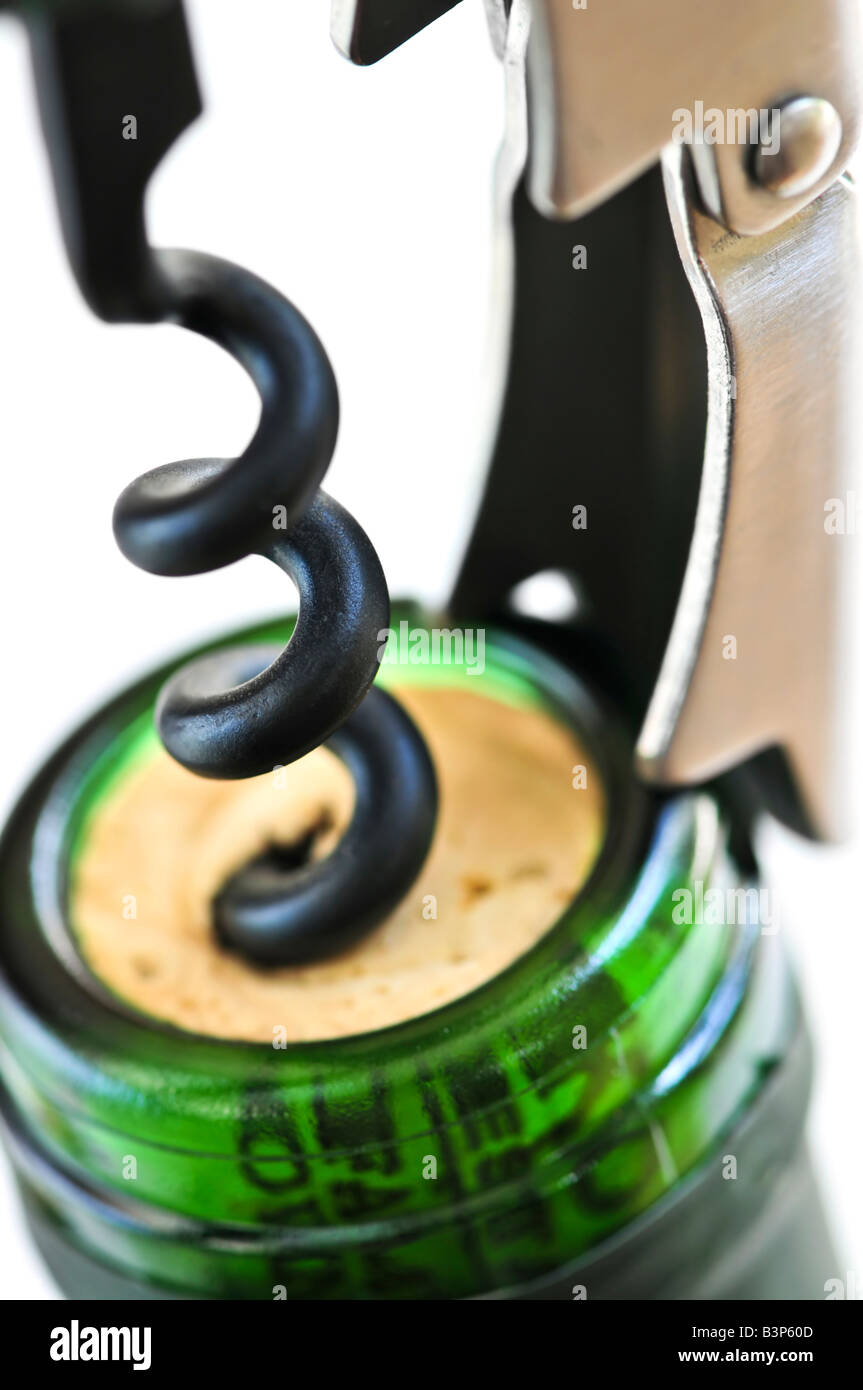 Opening wine bottle with a corkscrew on white background Stock Photo