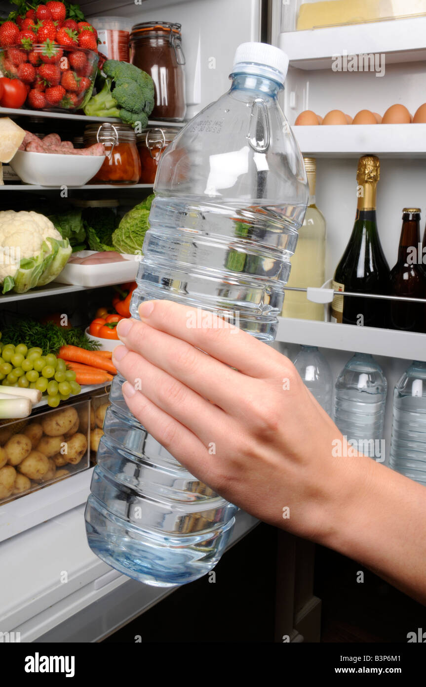 MAN TAKING BOTTLE OF MINERAL WATER FROM REFRIGERATOR Stock Photo Alamy