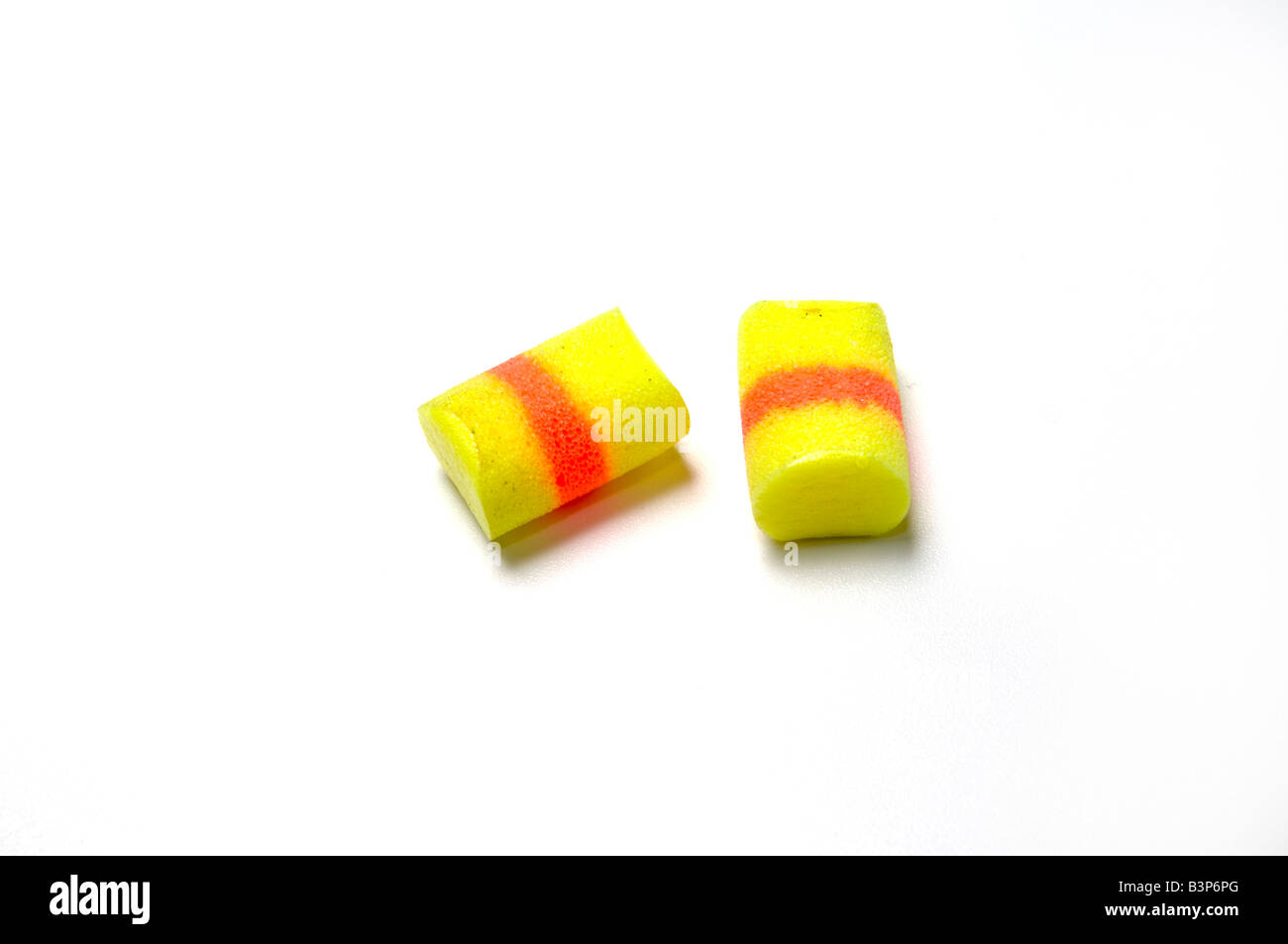 A pair of yellow earplugs used to reduce noise including noise caused by snoring Stock Photo