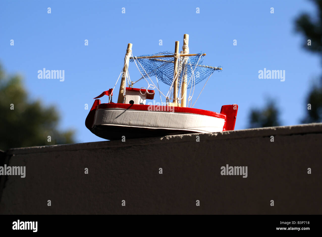 https://c8.alamy.com/comp/B3P718/a-small-toy-ship-placed-onto-a-fence-B3P718.jpg