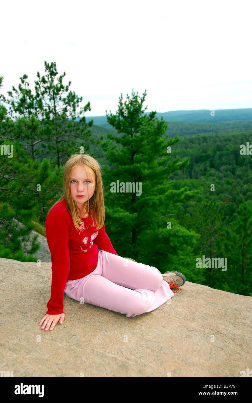 Young girl sitting on an edge of a cliff Stock Photo - Alamy
