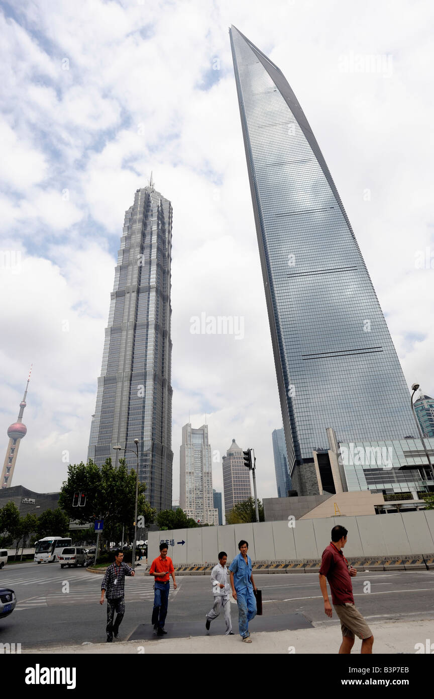 Chinese workers walk past Shanghai World Financial Center and Jinmao Tower. 07-Sep-2008 Stock Photo