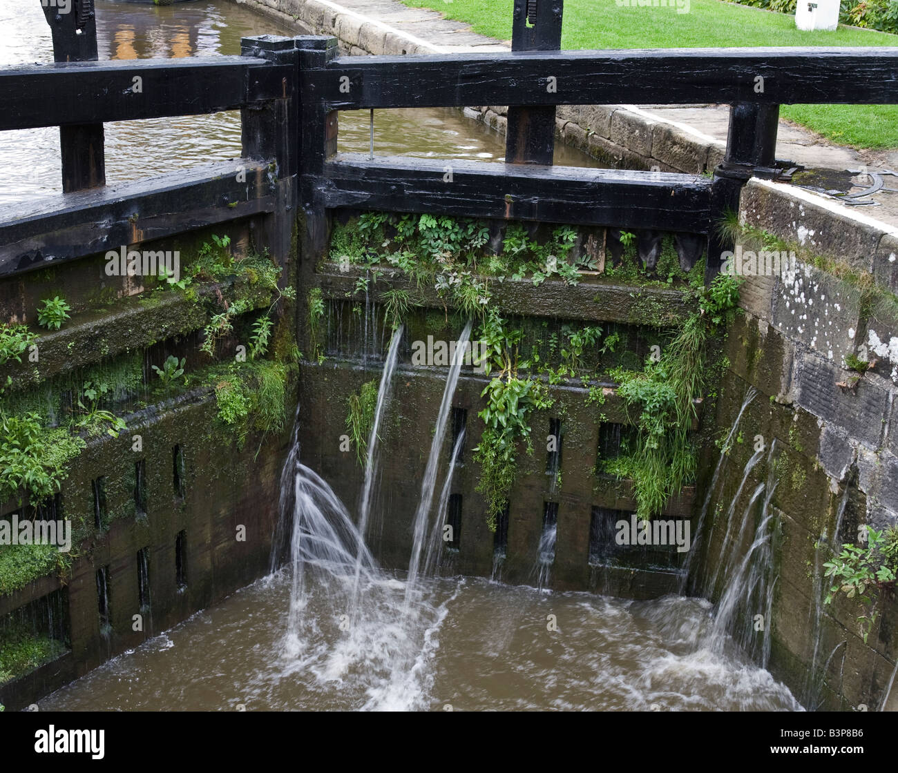 Canal lock gates transferring water to a lower lock Stock Photo Alamy