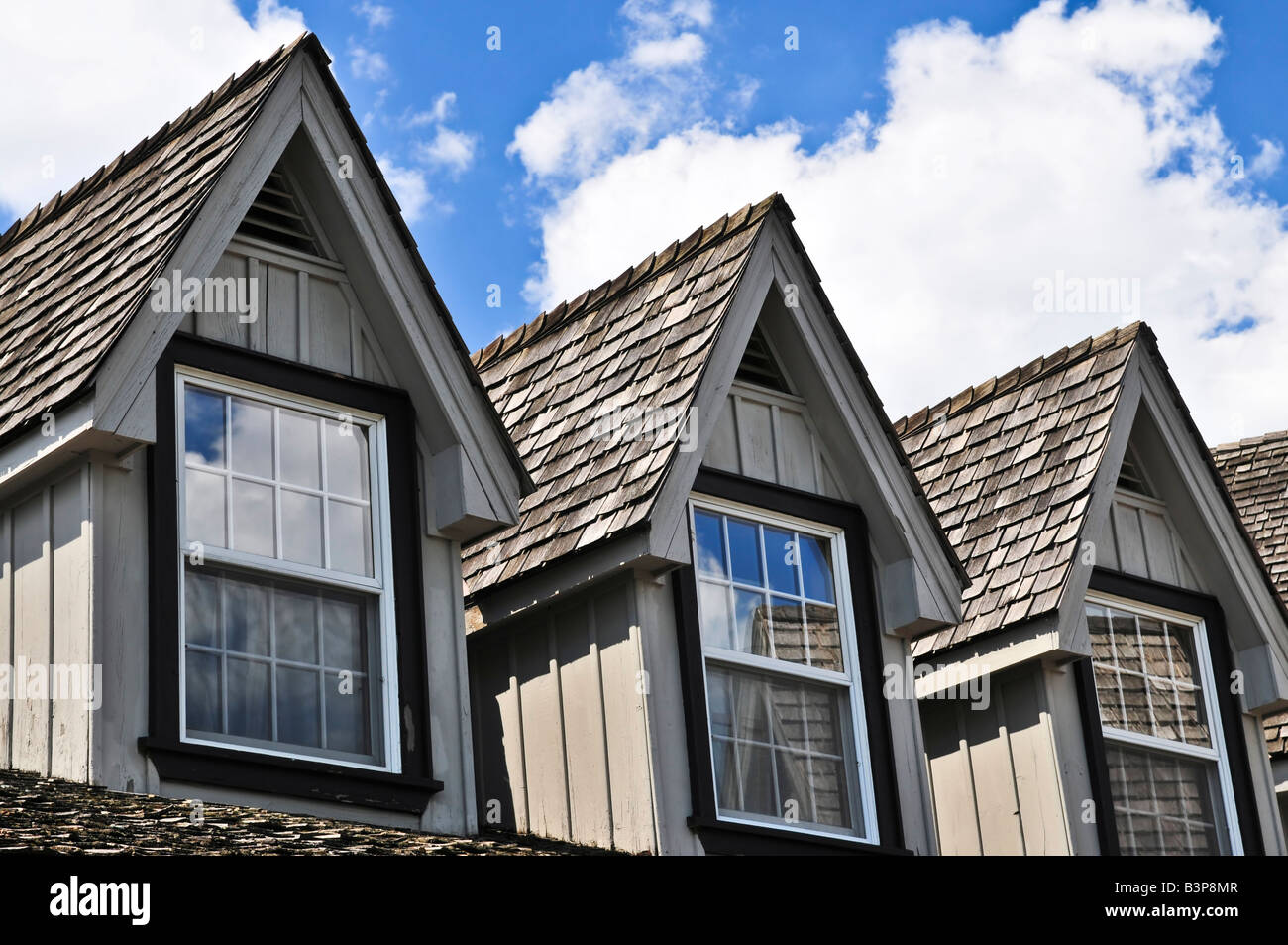 Window Dormers On A House With Wooden Shingles On Blue Sky