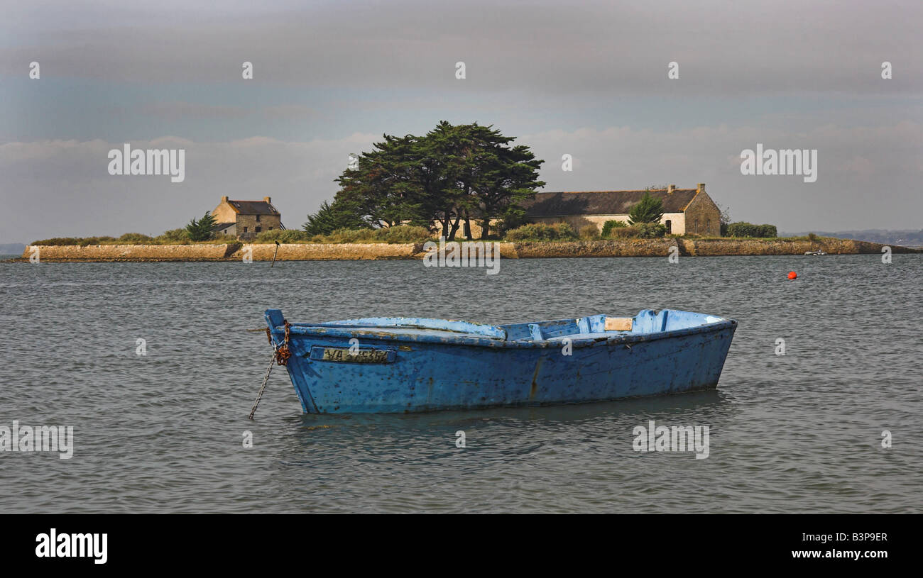 Blue rowing boat anchored in a lagoon off the coast of Britanny, France ...