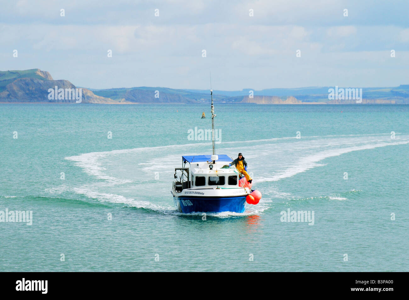Fishing boat heading into the harbour at Lyme Regis in Dorset Stock ...