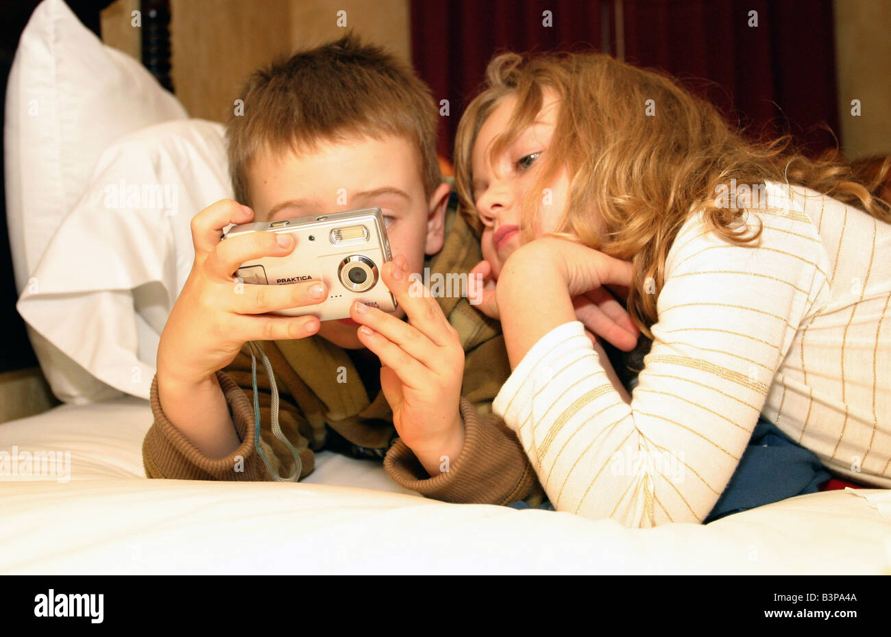 boy and girl looking at digital camera Stock Photo - Alamy