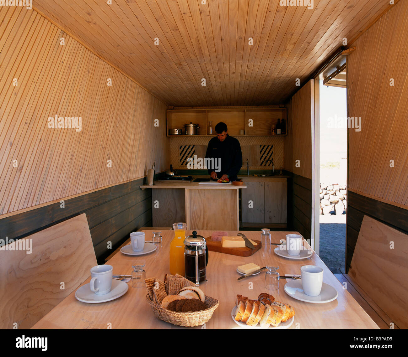 Chile, Parque Nacional Volcan Isluga. Camping in style. Chef prepares breakfast inside Explora's camp kitchen and dining room Stock Photo