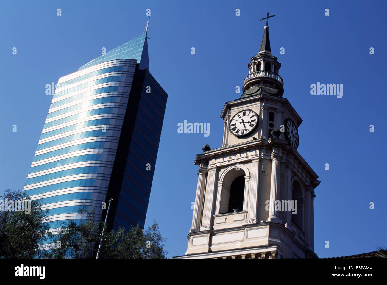 Chile, Santiago. Rising either side of Avenida del Libertador Bernardo O'Higgins, Santiago's main east-west throughfare, colloquially known as La Alameda, are the two faces of Santiago. On the left a modern high-rise office building and on the right the tower of Iglesia San Francisco, Santiago's oldest building (built in 1586-1628AD) Stock Photo
