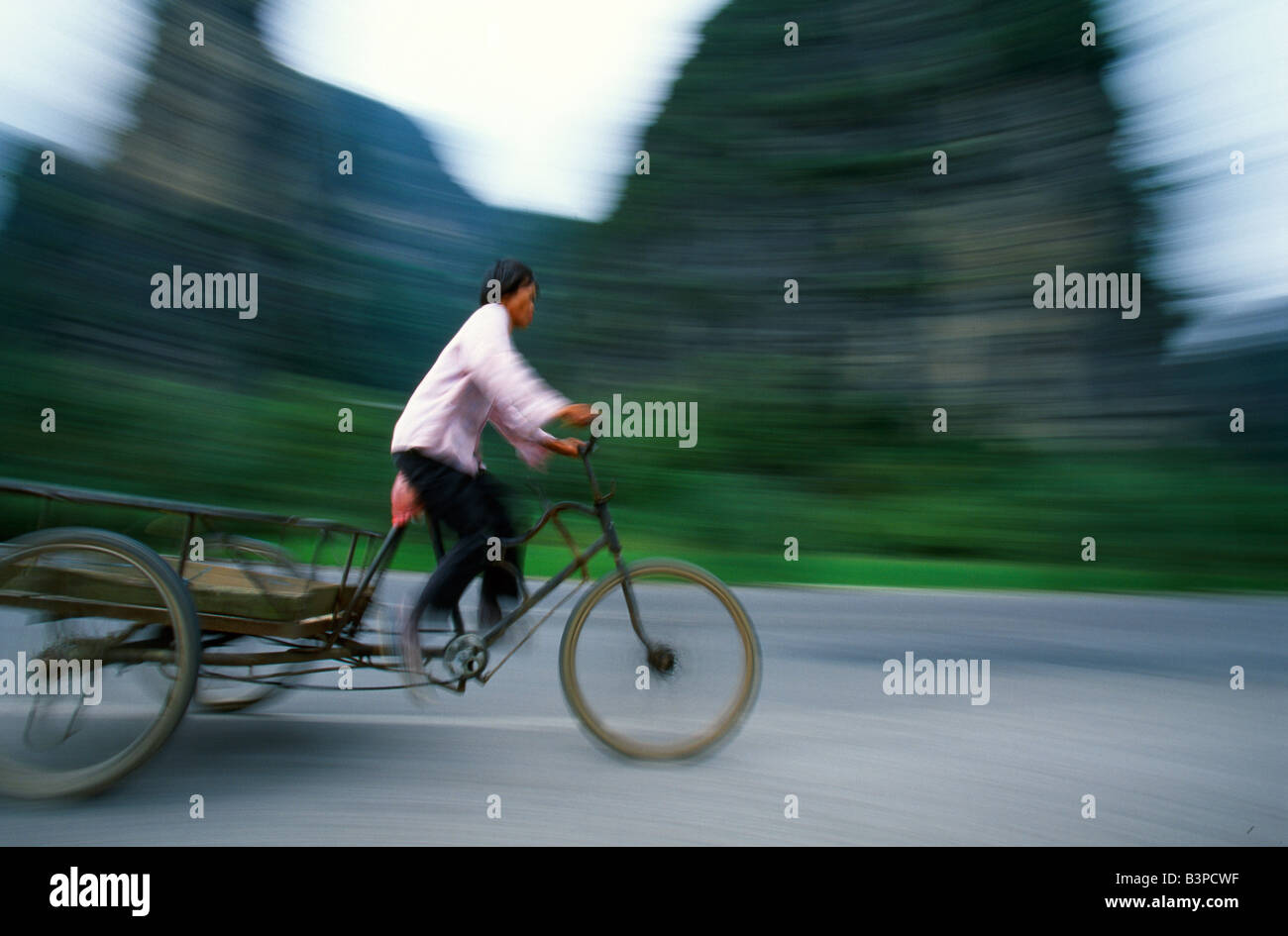 China, Guangxi Province. Woman on a three-wheel 'flatback'. Stock Photo
