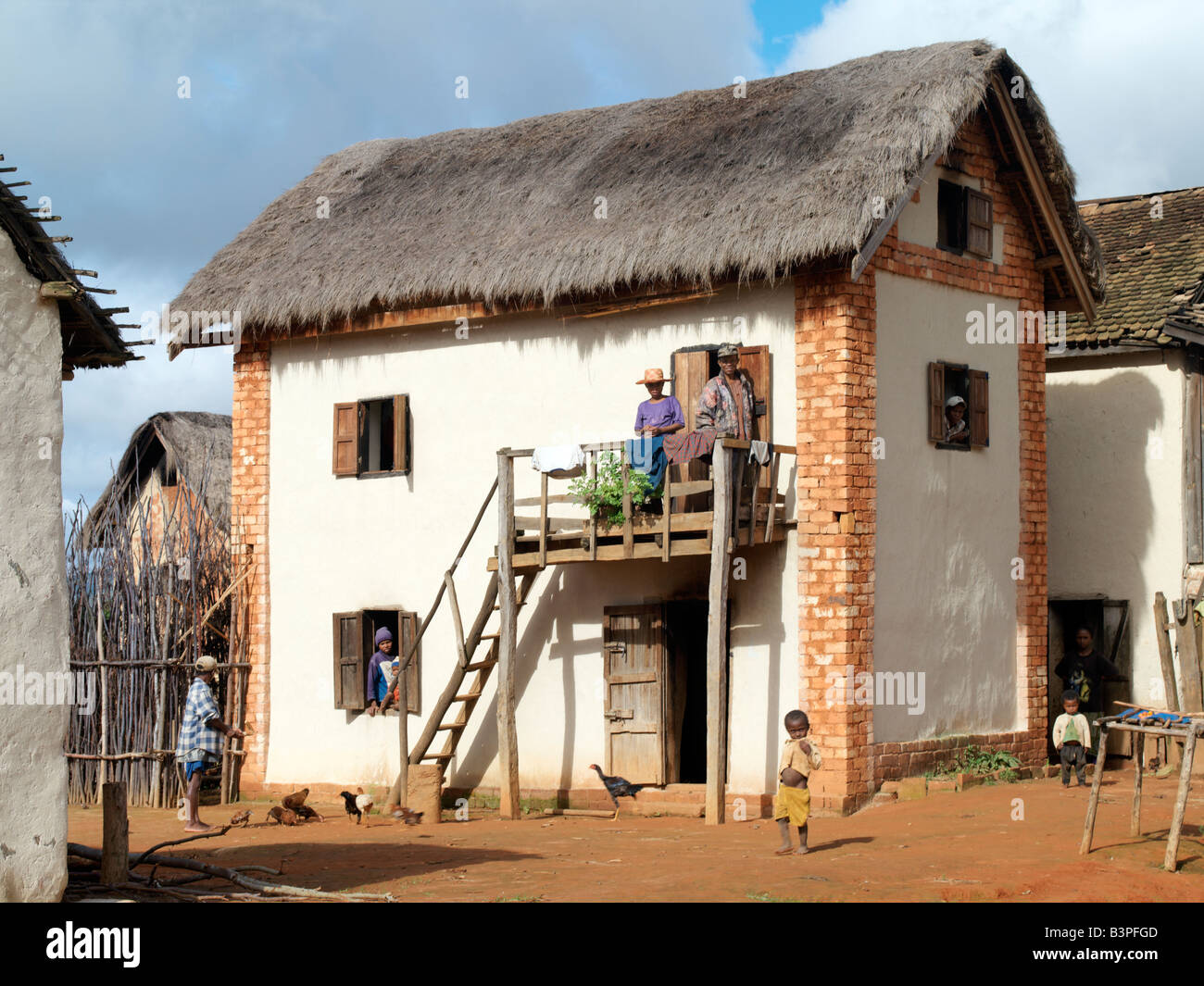 Madagascar, Southern Highlands, Andohatangona. An attractive Malagasy home of the Betsileo people who live southwest of the capital, Antananarivo.Most houses built by the Betsileo are double-storied with kitchens and living quarters located on the first floor. Almost all of them have wooden balconies and some have outside staircases. Livestock is often kept in the ground floor of a house overnight.The Betsileo are industrious people and expert rice farmers. Their terraced, irrigated paddy fields are a feature of Madagascar's southern landscape. Stock Photo
