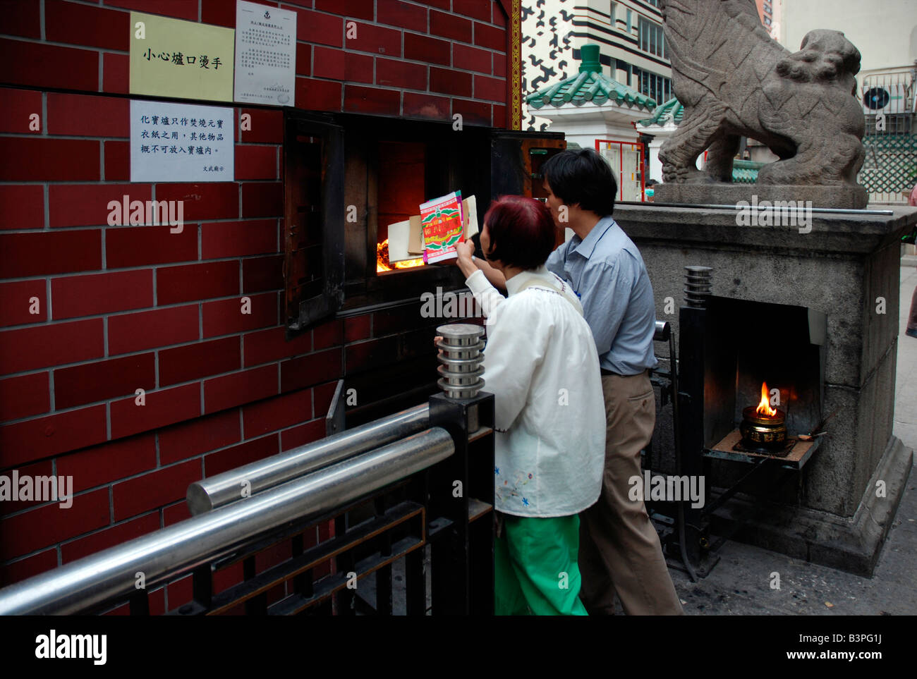 Worshipers burning paper for good luck Man Mo Taoist temple in Hong Kong China Stock Photo