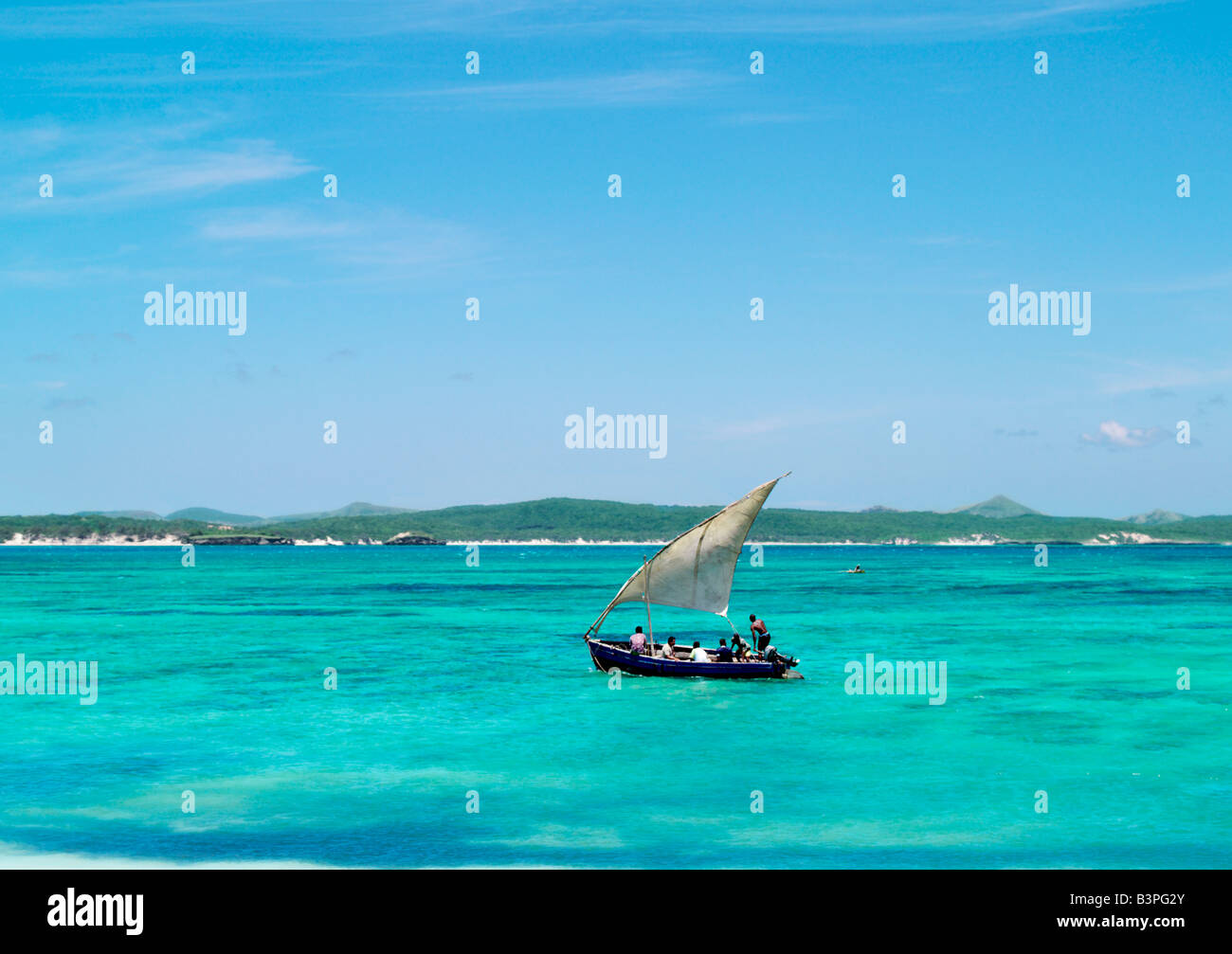 Northern  Madagascar, A fishing boat sails off Suarez Island in the crystal-clear waters of Mer d'Emeraude (Emerald Sea).  This Stock Photo