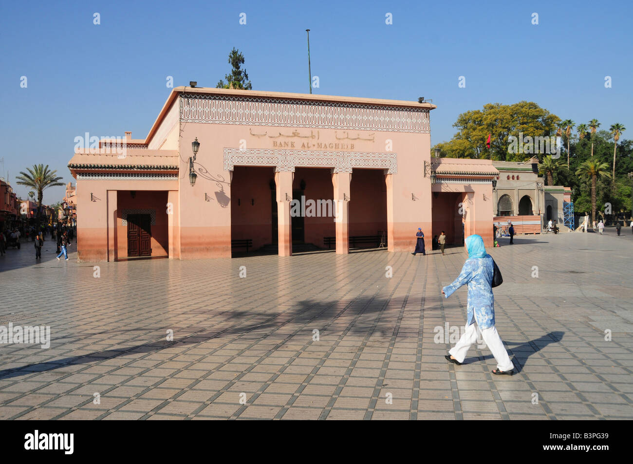 Veiled woman in front of the al-Maghrib bank on Djemma el-Fna Square, 'imposters square' or 'square of the hanged', Marrakesh,  Stock Photo