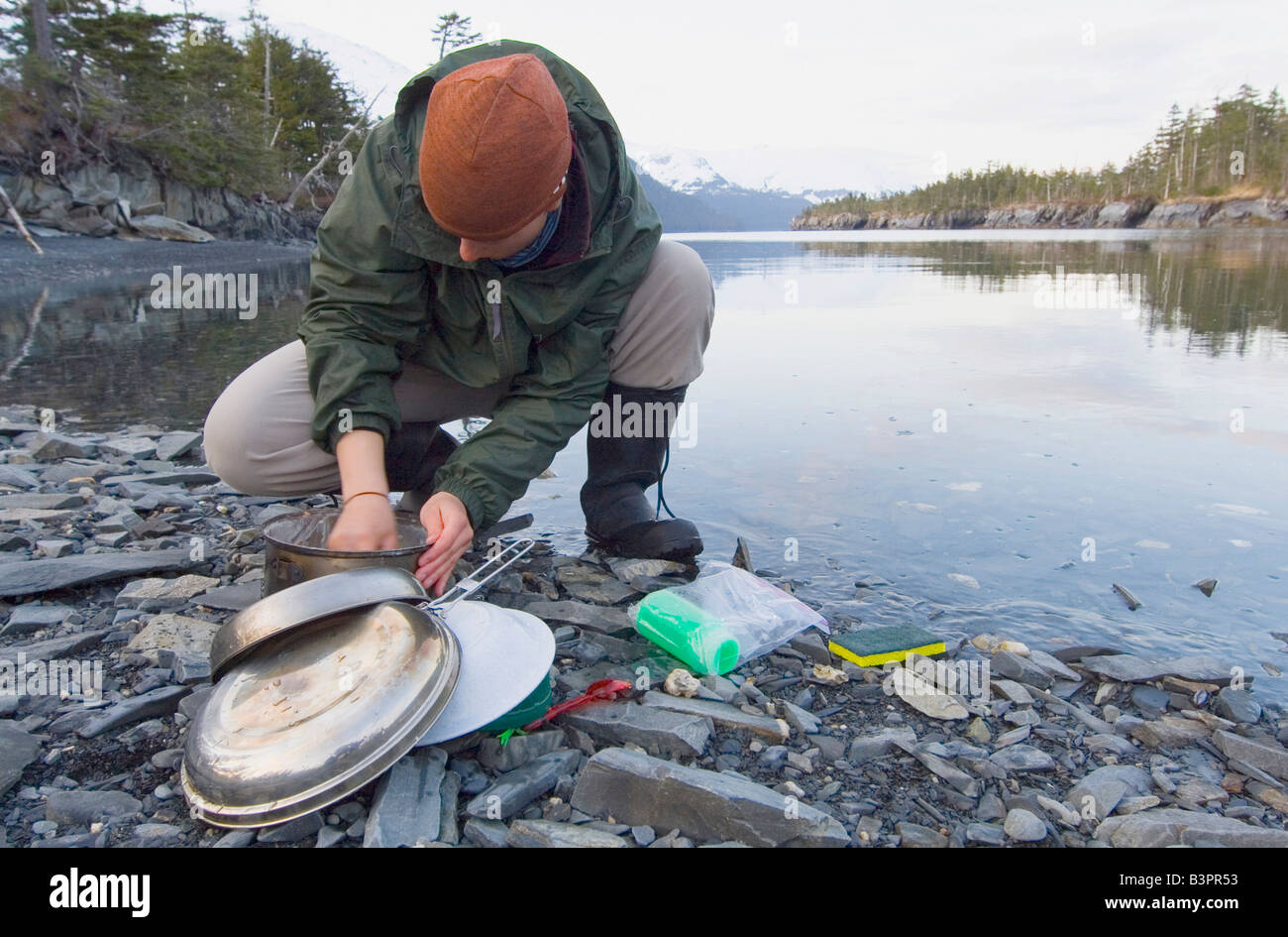 Washing dishes outdoors, riverside, evening, Pacific Coast, Prince William Sound, Chugach National Forest, Alaska, USA Stock Photo
