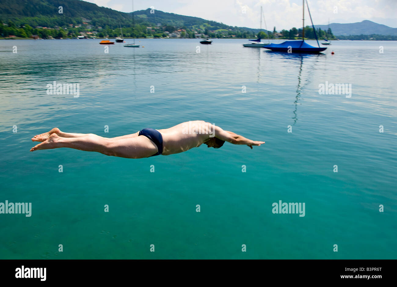 Man diving head-first into Lake Woerthersee, Carinthia, Austria, Europe Stock Photo