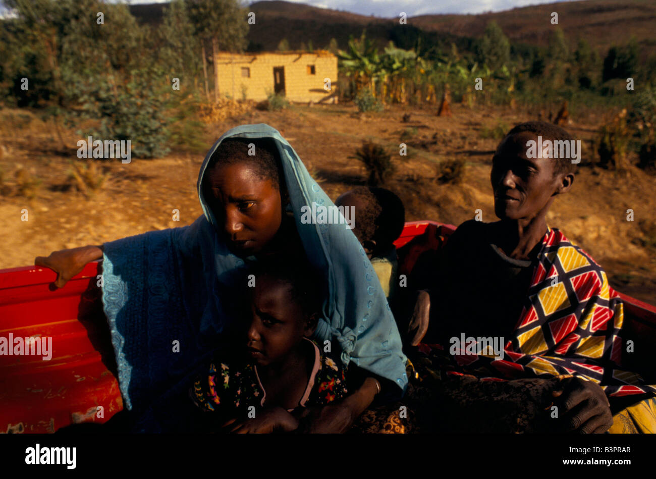 Tutsi family returning to the camp at Ruyigi pass burnt out houses Stock Photo