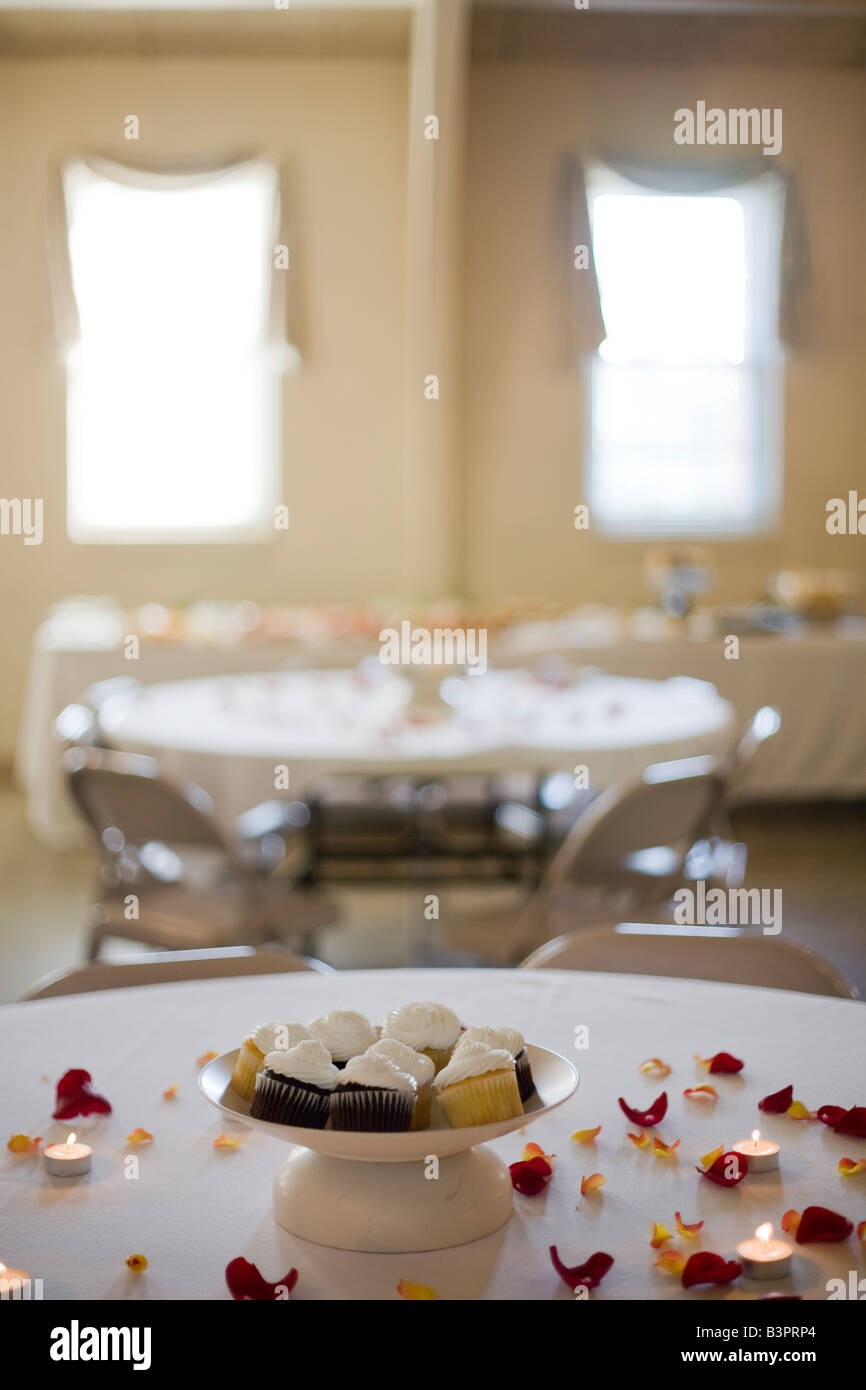 Tables In A Reception Hall Decorated With Cupcakes Rose Petals