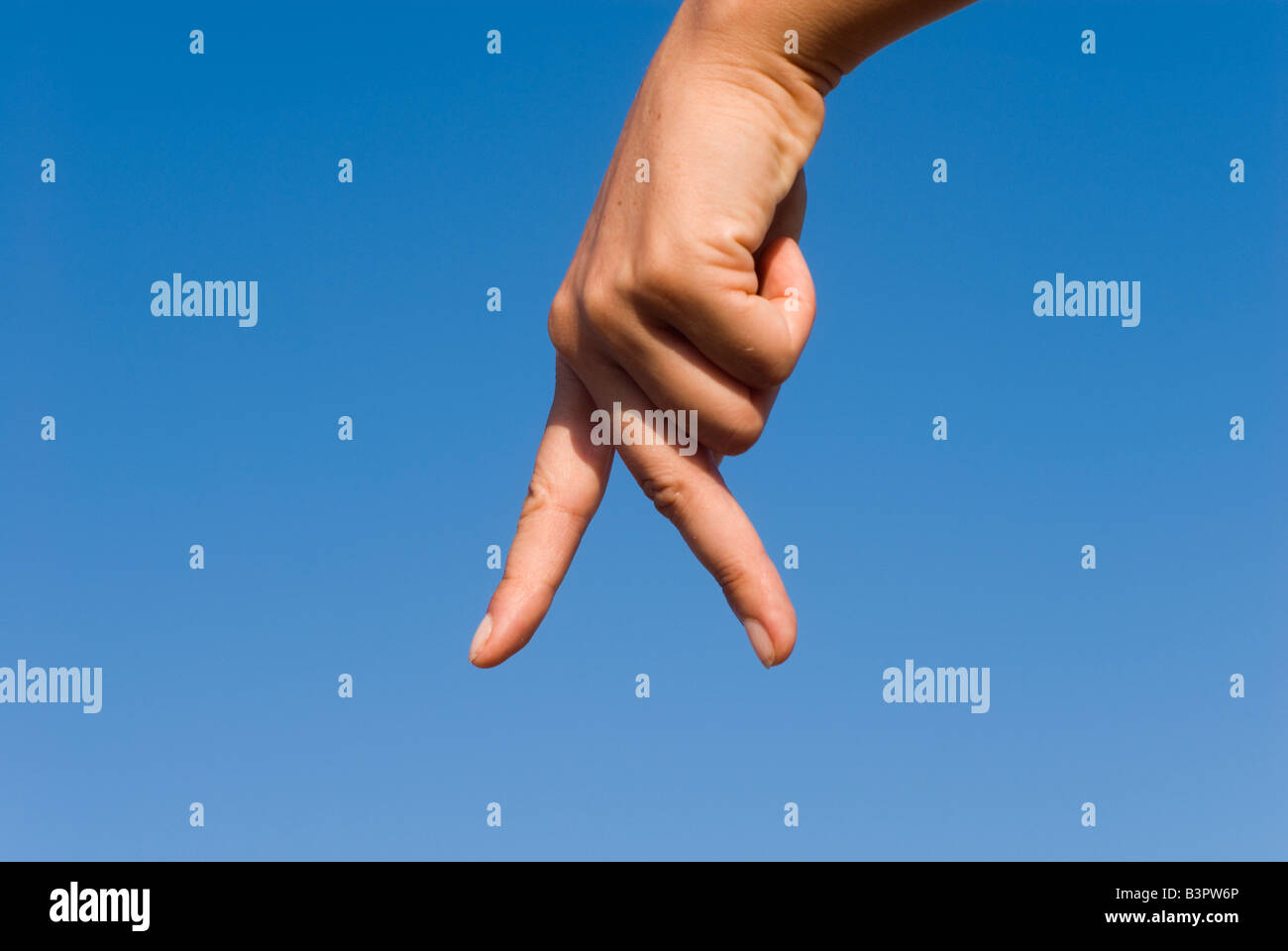 Model Released Detail of female hand forming a walking sign Stock Photo