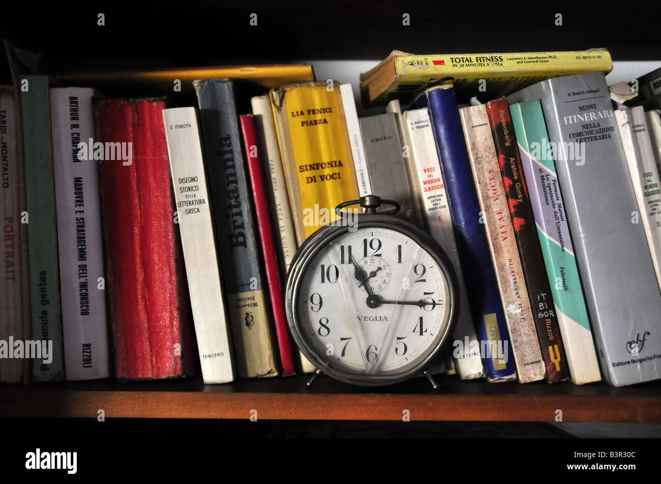 shelf with books and old alarm clock Stock Photo Alamy