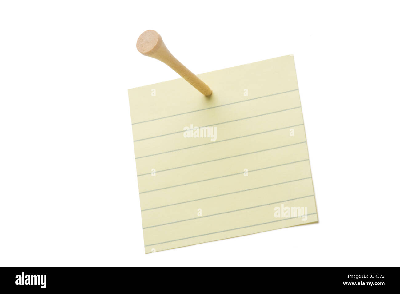 Lined yellow sticky note nailed with wood golf tee to white background Stock Photo