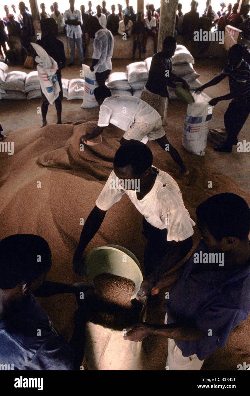 MEN STACKING SACKS OF 'USA' FOOD AID BROUGHT BY AGENCIES TO PEOPLE RE OCCUPYING VILLAGES LIBERTATED FROM THE REBELS, POTORU Stock Photo