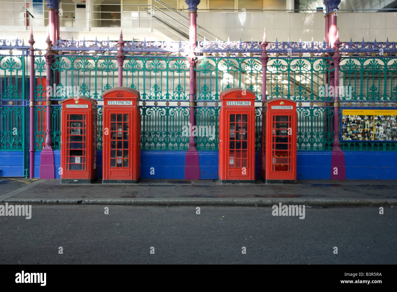 Four red London phone boxes in a row note the different sizes Stock Photo