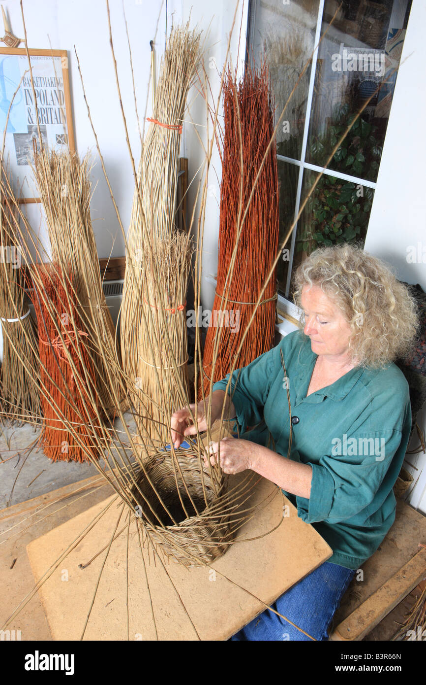 Norah Kennedy making a traditional willow basket in her workshop in The Stroud Valley Gloucestershire England Stock Photo