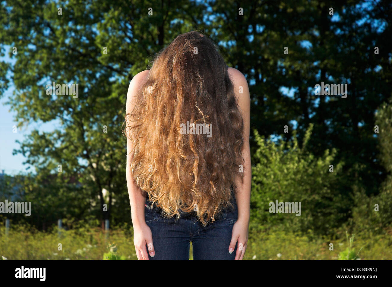 Teenage girl 16 18 with long curly hair bending over Stock Photo