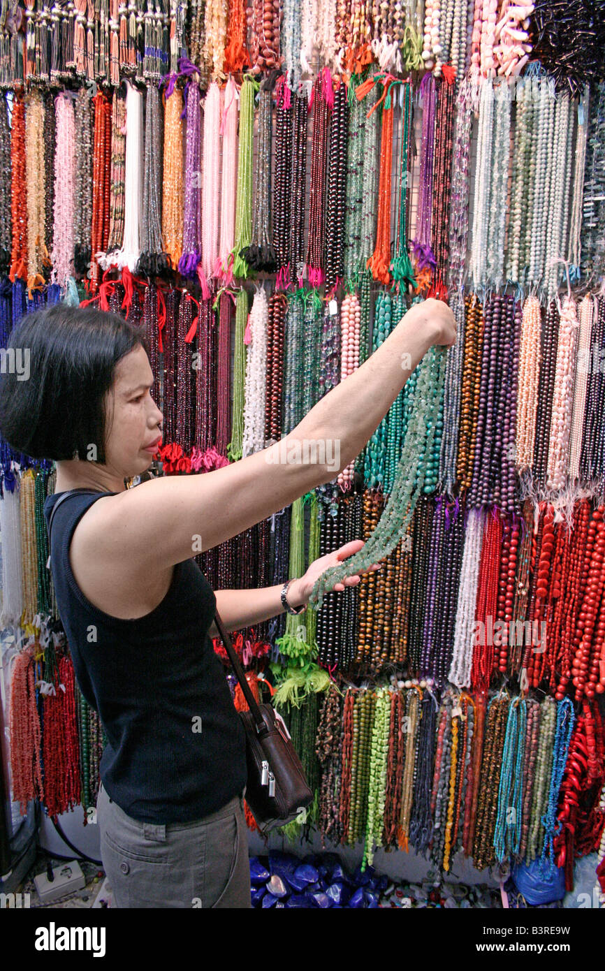 Oriental lady inspects a craft necklace before purchase, Thailand Stock Photo