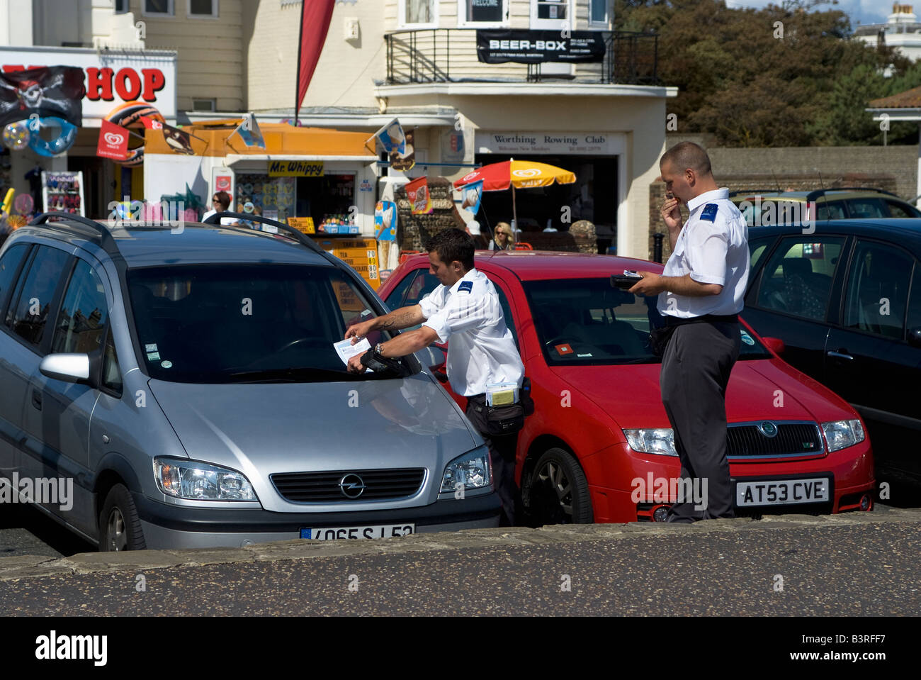 Traffic wardens issuing parking ticket on Worthing seafront West Sussex England Stock Photo