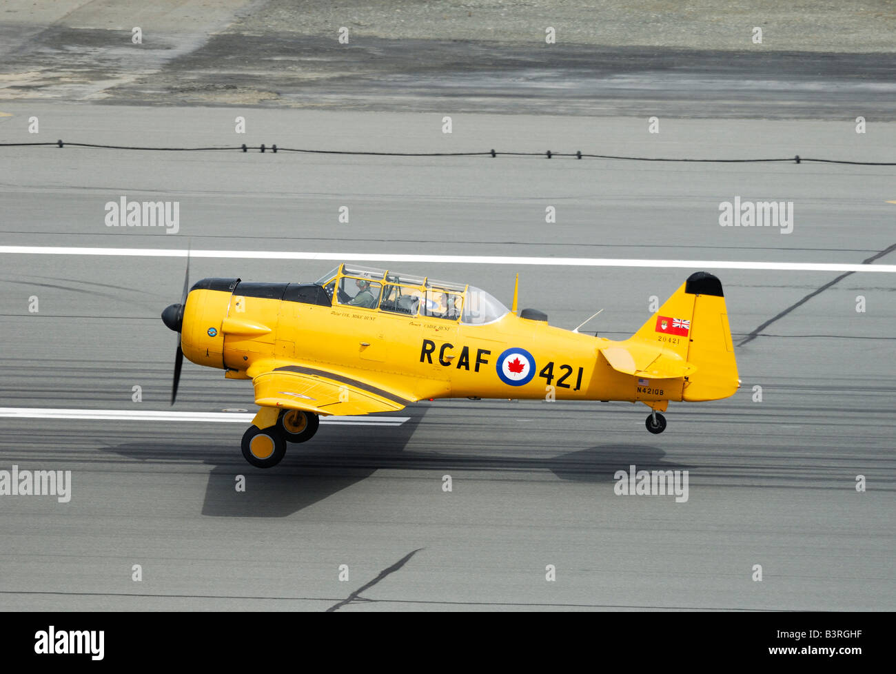 Old trainer plane North American AT-6 Texan taking off on the runway during an airshow in Alaska Stock Photo