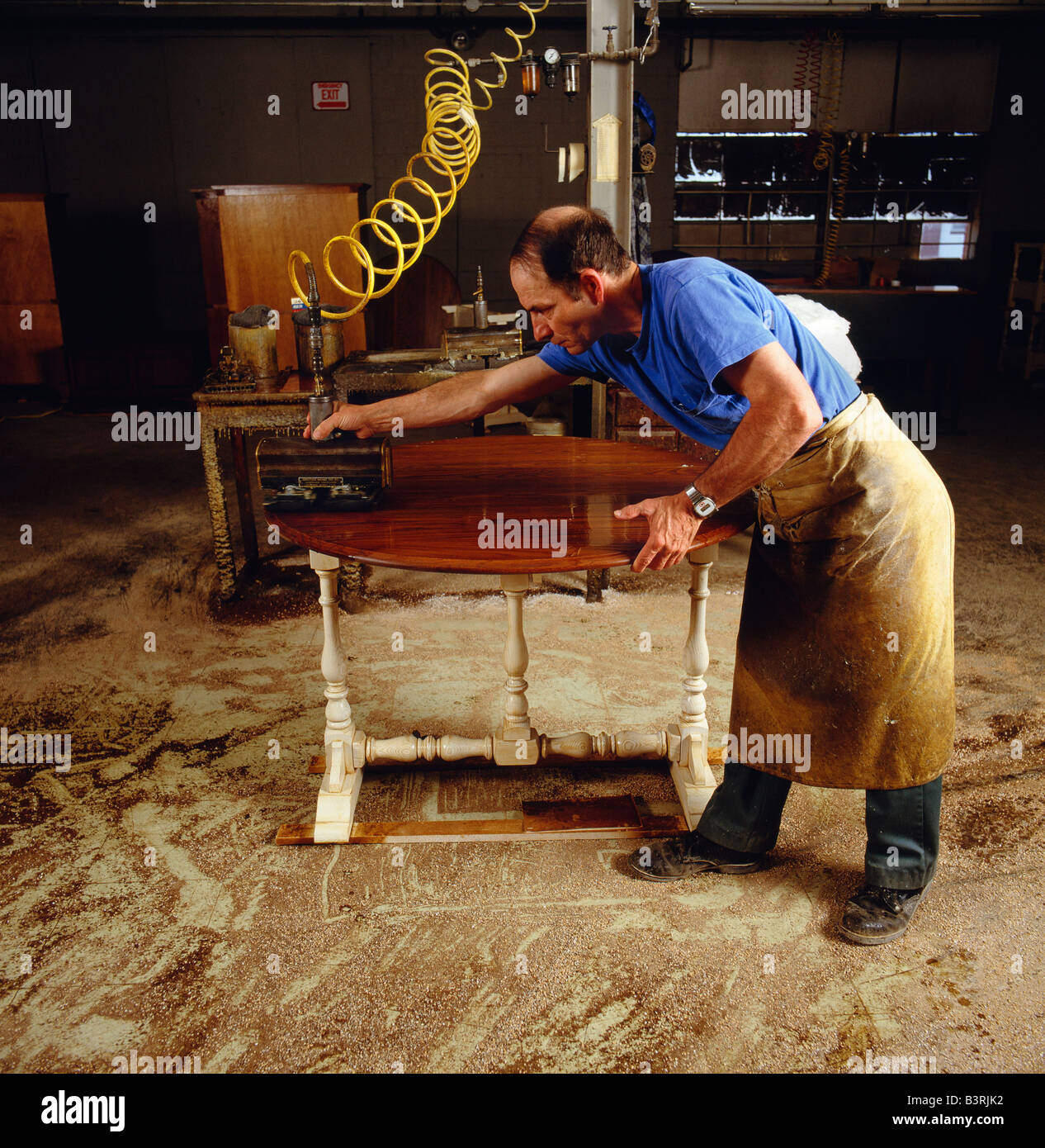 Worker Does The Final Polishing To A Piece Of Furniture