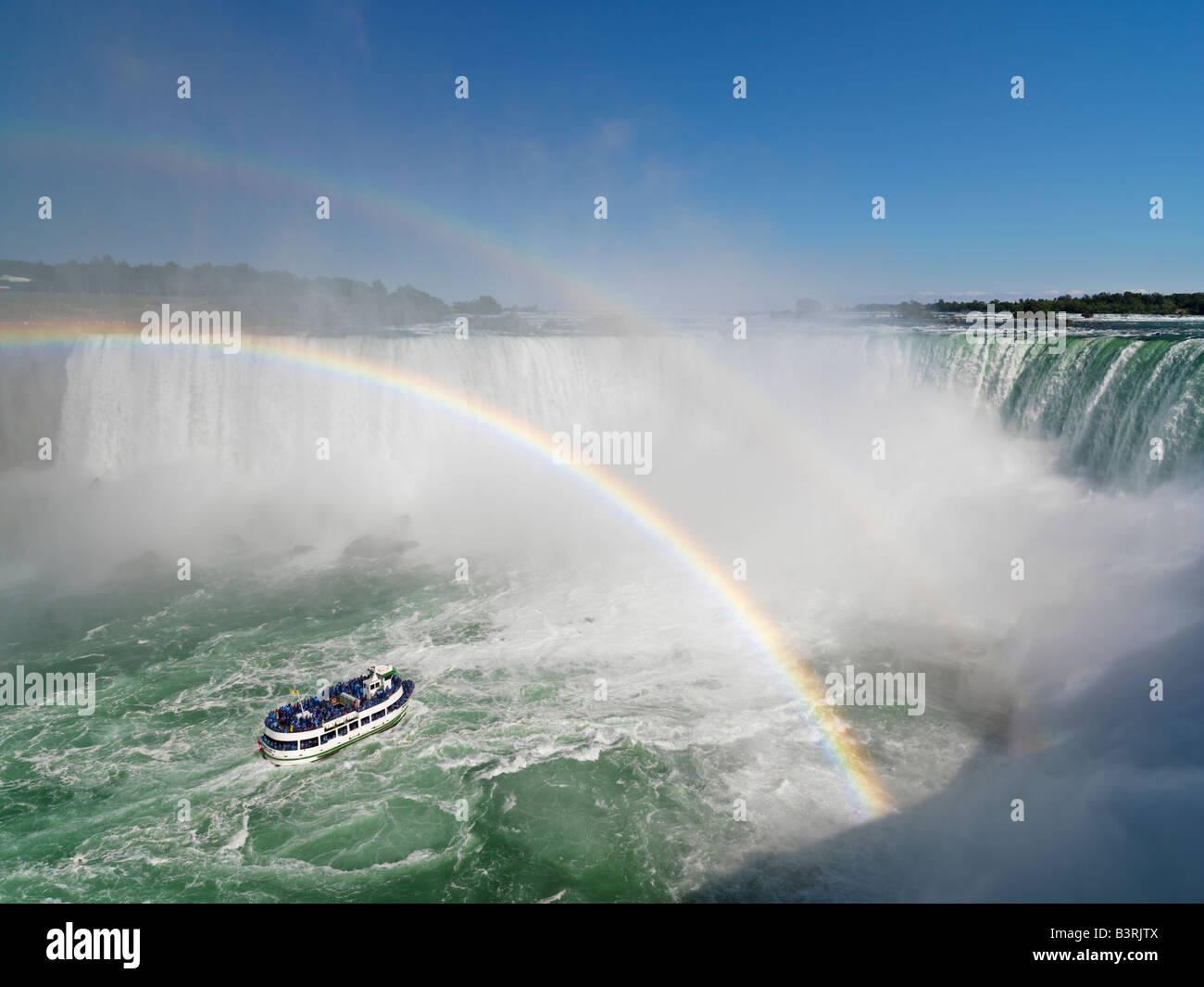 Canada,Ontario,Niagara Falls,Maid of the Mist tour boat approaching the Canadian Falls with a double rainbow Stock Photo