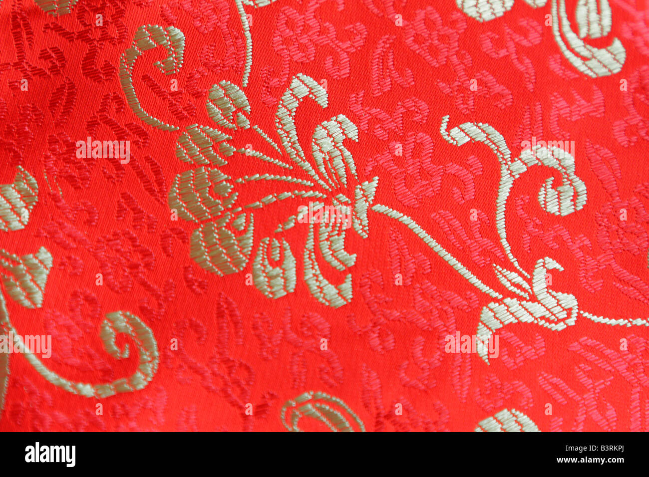 Flower design on red Chinese silk fabric Stock Photo