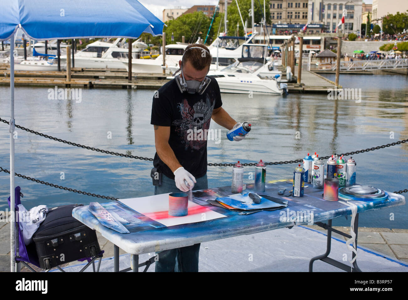 spray paint artist at work on harbourfront, Victoria, Vancouver Island, British Columbia, Canada Stock Photo